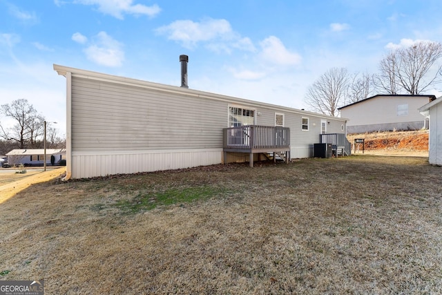 back of house featuring a lawn, a deck, and central air condition unit