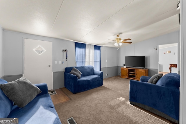 living room with ceiling fan, carpet, and a textured ceiling