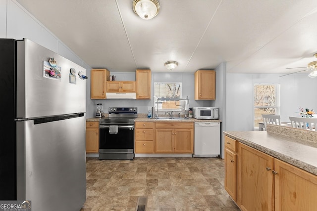 kitchen with ceiling fan, appliances with stainless steel finishes, light brown cabinetry, and sink