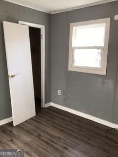 unfurnished bedroom featuring dark hardwood / wood-style flooring and a closet