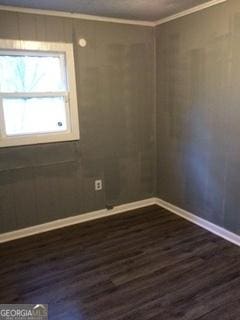 unfurnished room with crown molding and dark hardwood / wood-style floors