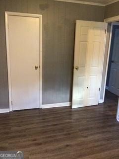 unfurnished bedroom featuring crown molding and dark hardwood / wood-style floors