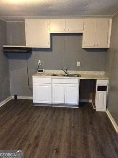 kitchen featuring dark hardwood / wood-style floors, sink, and white cabinets