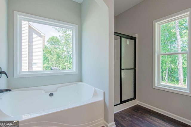 bathroom featuring hardwood / wood-style flooring, separate shower and tub, and a wealth of natural light