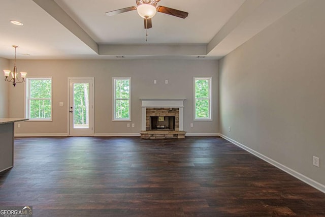 unfurnished living room with a healthy amount of sunlight, a fireplace, and a tray ceiling