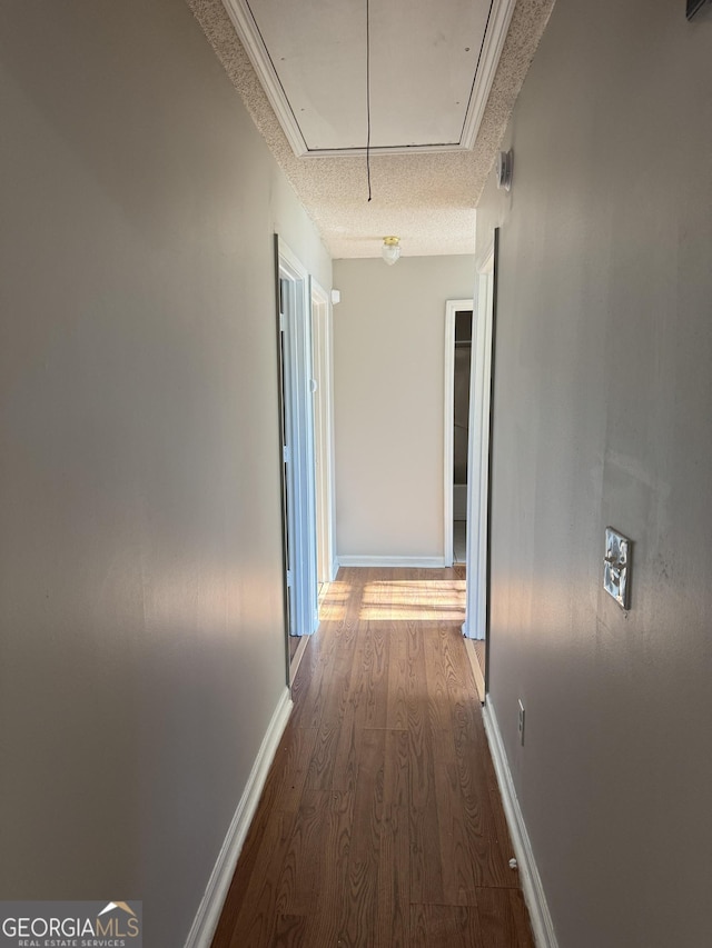 corridor featuring hardwood / wood-style floors and a textured ceiling