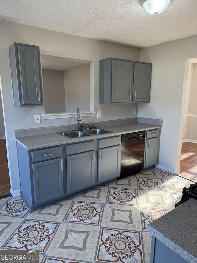 kitchen featuring gray cabinets, black dishwasher, sink, and a textured ceiling