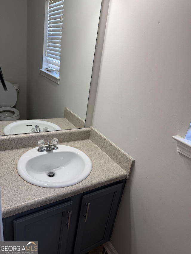 bathroom featuring vanity and toilet