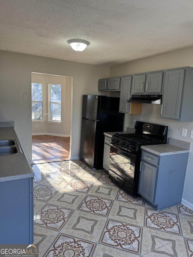 kitchen featuring gray cabinetry, sink, black appliances, and a textured ceiling