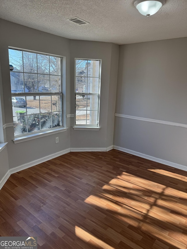 unfurnished room featuring hardwood / wood-style floors and a textured ceiling