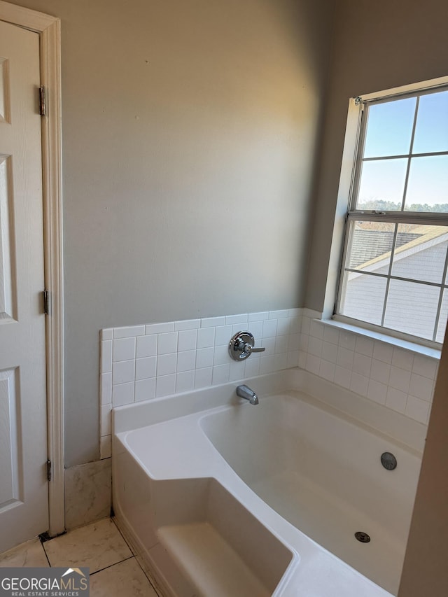 bathroom with tile patterned flooring and a tub to relax in