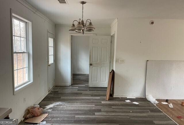 unfurnished dining area with crown molding, dark hardwood / wood-style flooring, and a wealth of natural light