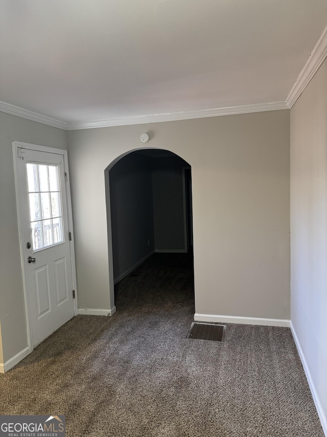 unfurnished room with dark colored carpet and crown molding