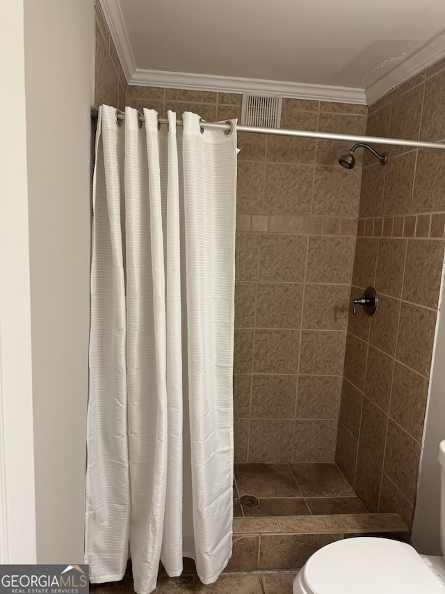 bathroom featuring crown molding, toilet, and walk in shower