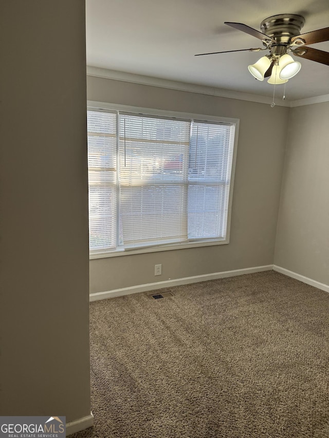 empty room featuring crown molding, carpet, and ceiling fan