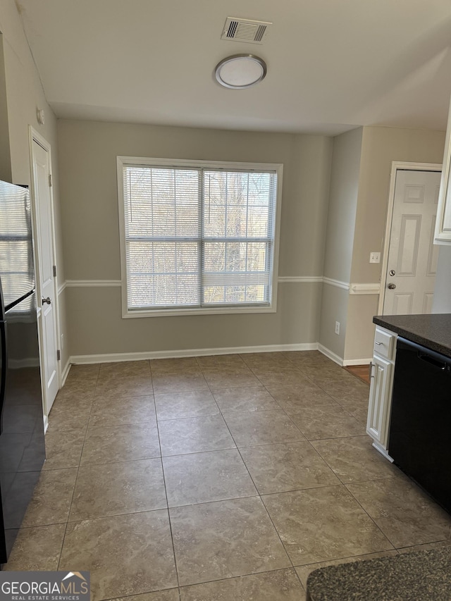 unfurnished dining area featuring light tile patterned flooring