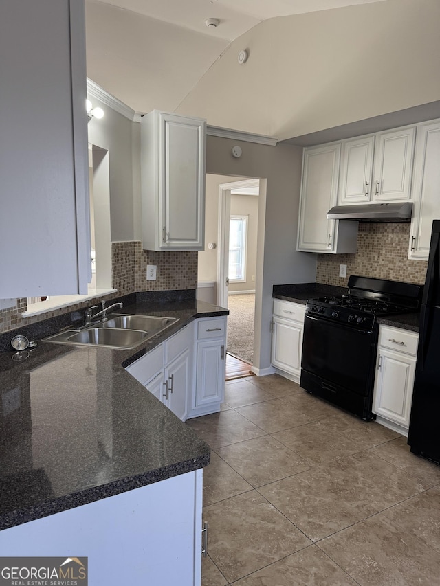 kitchen with vaulted ceiling, tasteful backsplash, sink, white cabinets, and black appliances