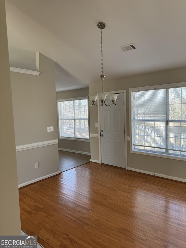 entryway with hardwood / wood-style floors, plenty of natural light, and a chandelier