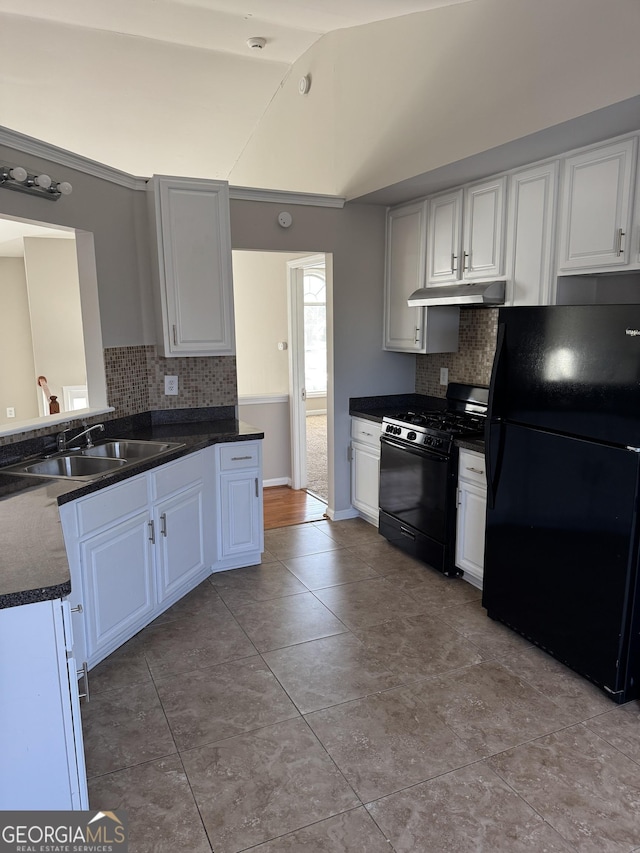 kitchen featuring sink, white cabinetry, tasteful backsplash, black appliances, and vaulted ceiling