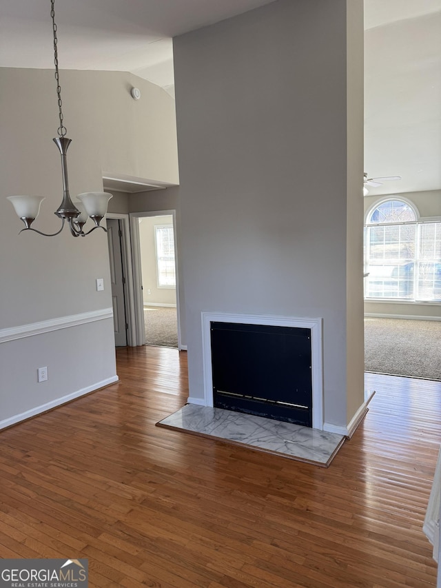 room details featuring hardwood / wood-style flooring and ceiling fan with notable chandelier