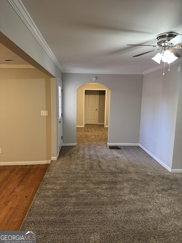 empty room featuring ornamental molding, dark hardwood / wood-style flooring, and ceiling fan