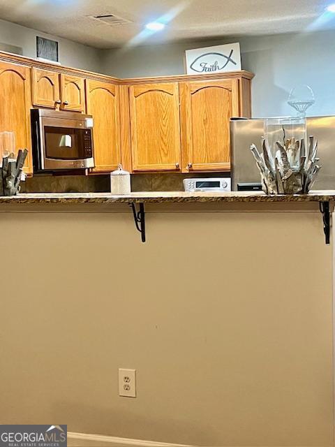 kitchen featuring a kitchen bar and appliances with stainless steel finishes