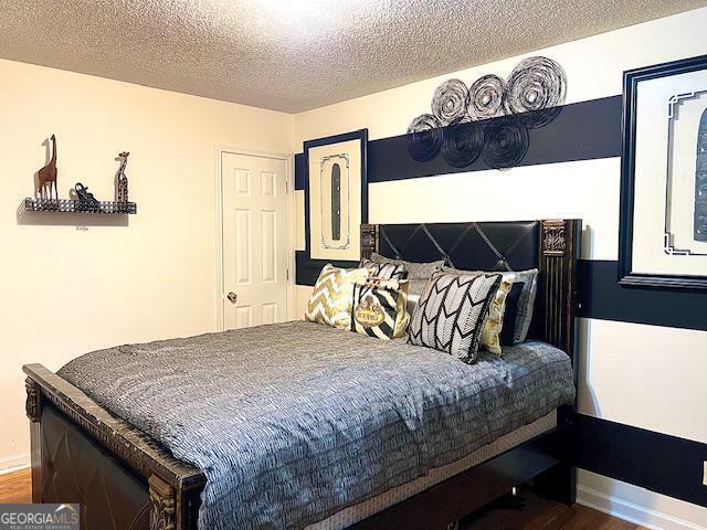 bedroom with hardwood / wood-style flooring and a textured ceiling