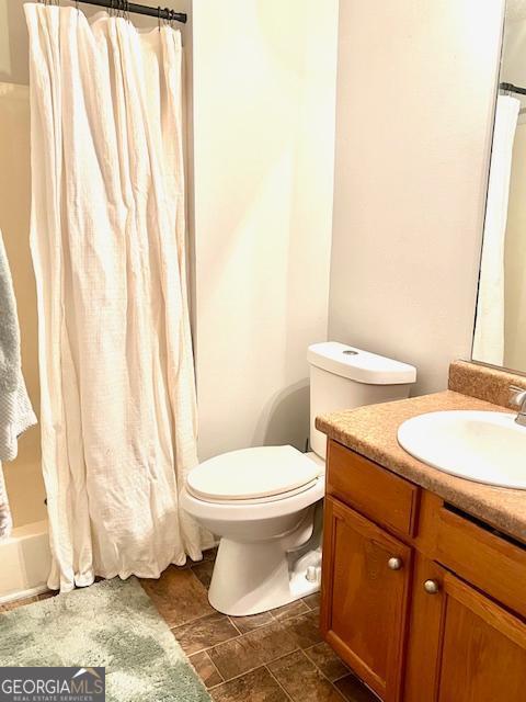 full bathroom featuring vanity, shower / tub combo with curtain, and toilet