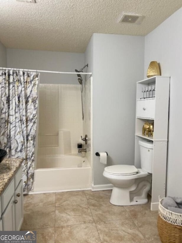 full bathroom featuring vanity, toilet, shower / bath combo with shower curtain, and a textured ceiling