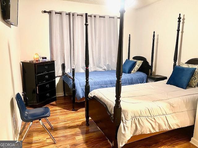 bedroom featuring wood-type flooring and a textured ceiling