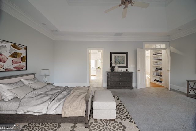 bedroom featuring ceiling fan, ornamental molding, a raised ceiling, and light carpet