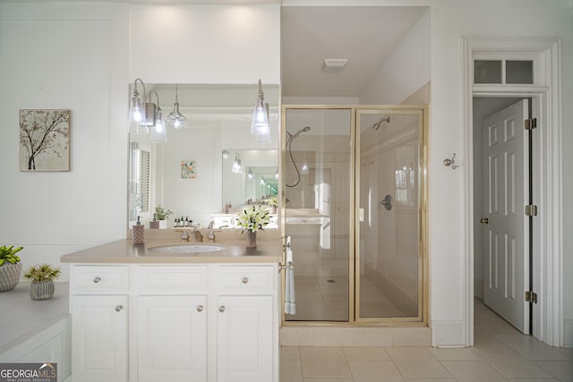 bathroom with vanity, a shower with shower door, and tile patterned floors