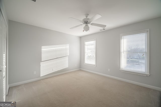 carpeted empty room featuring ceiling fan