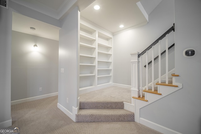 stairway featuring crown molding and carpet floors