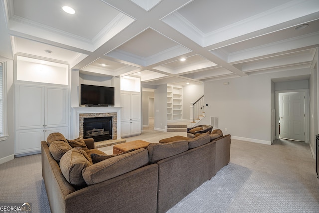 living room featuring coffered ceiling, a fireplace, light colored carpet, and beamed ceiling