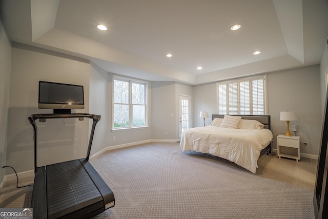 carpeted bedroom with a tray ceiling