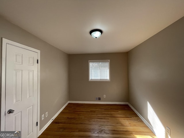 unfurnished room with wood-type flooring