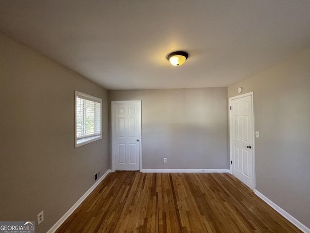 unfurnished room with hardwood / wood-style floors