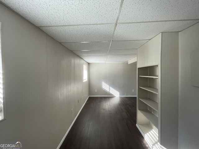 unfurnished room featuring a paneled ceiling and dark hardwood / wood-style floors