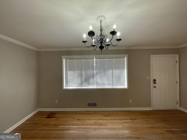 unfurnished dining area with crown molding, hardwood / wood-style floors, and a notable chandelier