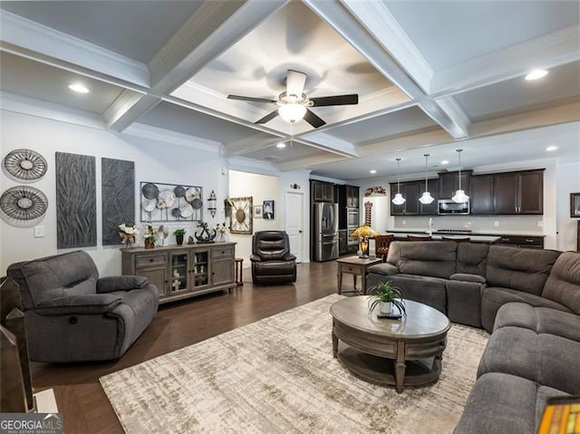 living room featuring dark hardwood / wood-style floors, beamed ceiling, coffered ceiling, ceiling fan, and crown molding