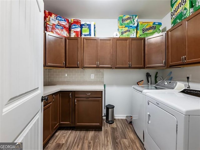 laundry room with cabinets, dark hardwood / wood-style flooring, and washer and clothes dryer