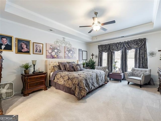 carpeted bedroom featuring a raised ceiling, ornamental molding, and ceiling fan