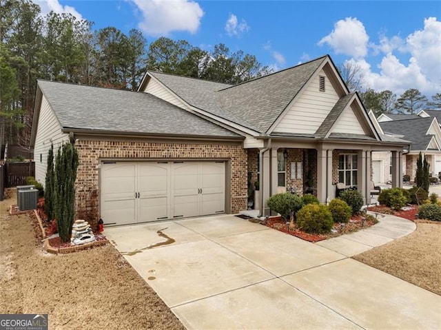 view of front of home with a garage and central air condition unit