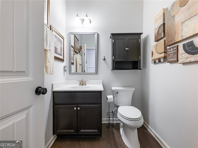 bathroom featuring vanity, wood-type flooring, and toilet