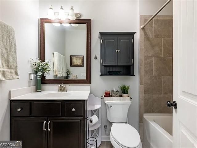 full bathroom featuring tiled shower / bath, vanity, and toilet