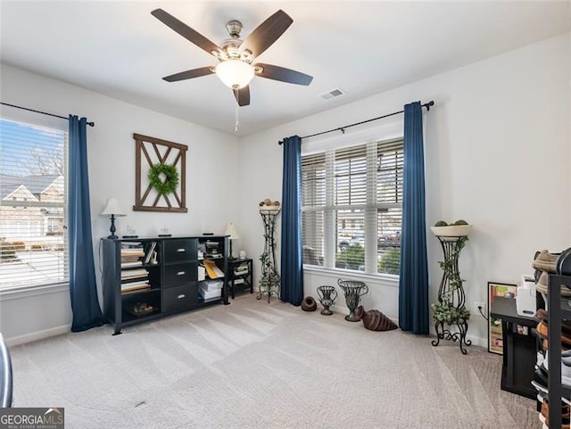 misc room with a wealth of natural light, light carpet, and ceiling fan