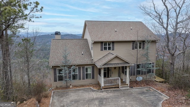 rear view of house featuring a porch and a mountain view