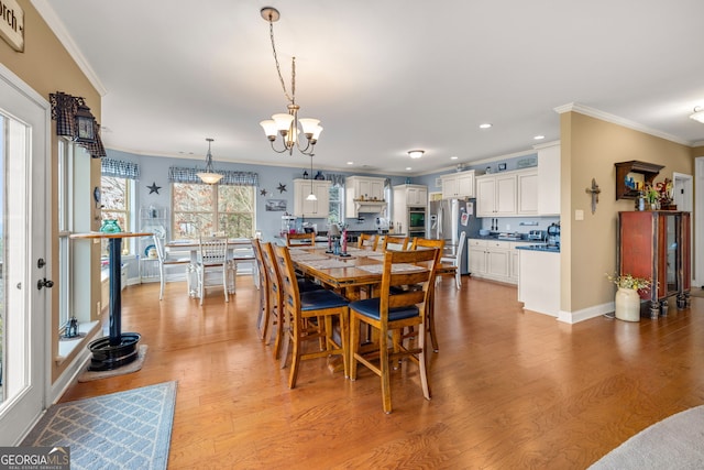 dining room with crown molding and light hardwood / wood-style flooring