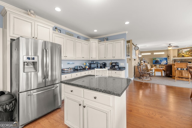 kitchen featuring a kitchen island, white cabinetry, light hardwood / wood-style floors, stainless steel fridge with ice dispenser, and crown molding